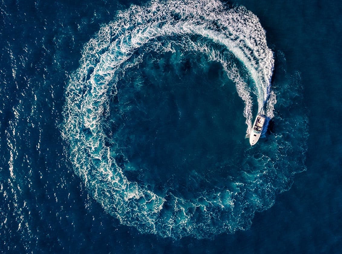 Aerial photograph of boat in water driving in a circle