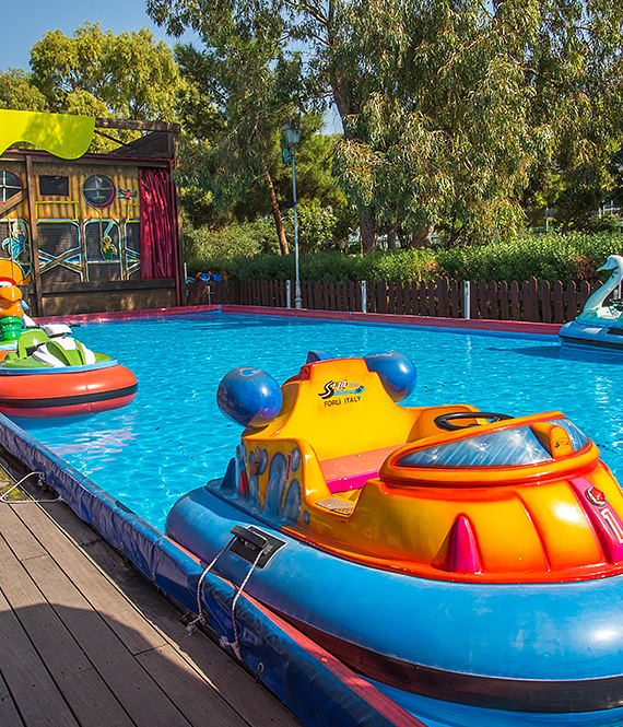 Colorful boat bumper cars in shallow pool at Volta Fun Town in Flisvos Marina, Athens