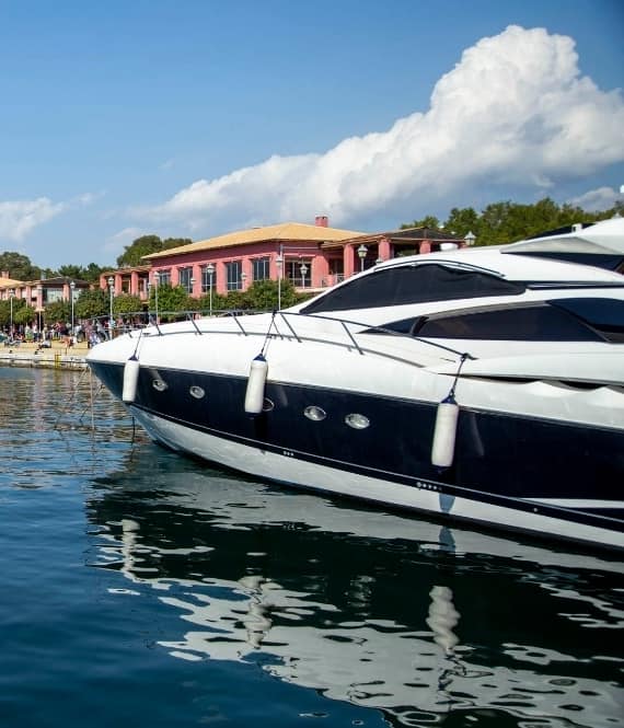 Docked white and black yacht in front of Flisvos Marina's buildings